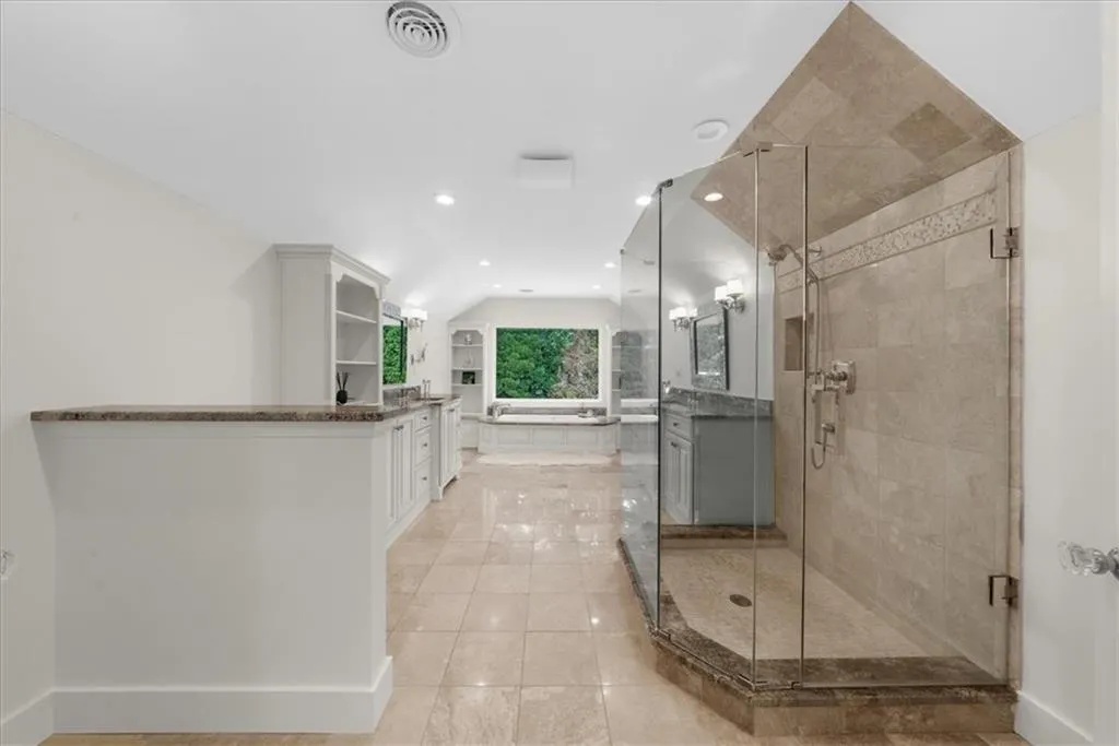 Full bath featuring vanity, a shower stall, lofted ceiling, recessed lighting, and tile patterned floors