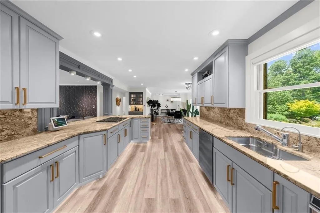 Kitchen with decorative backsplash, gray cabinets, crown molding, light wood finished floors, and open floor plan