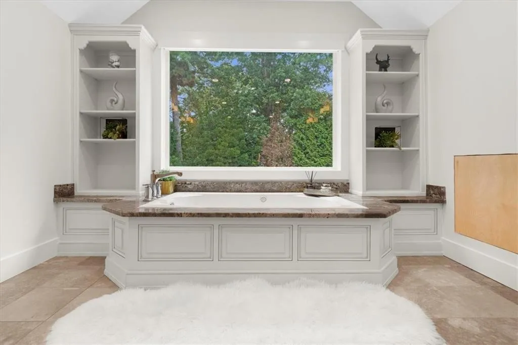 Full bathroom with built in features, a bath, healthy amount of natural light, tile patterned floors, and vaulted ceiling