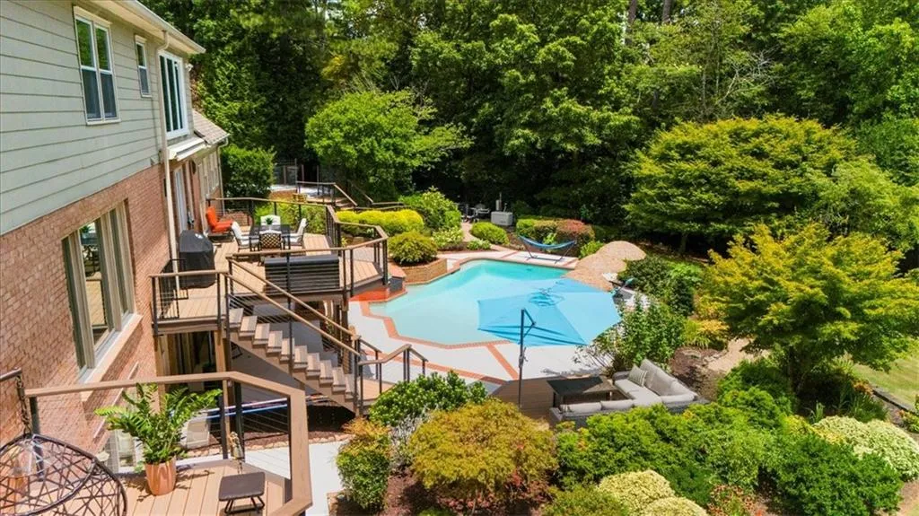 Outdoor pool with a deck, stairway, outdoor dining space, a patio, and area for grilling