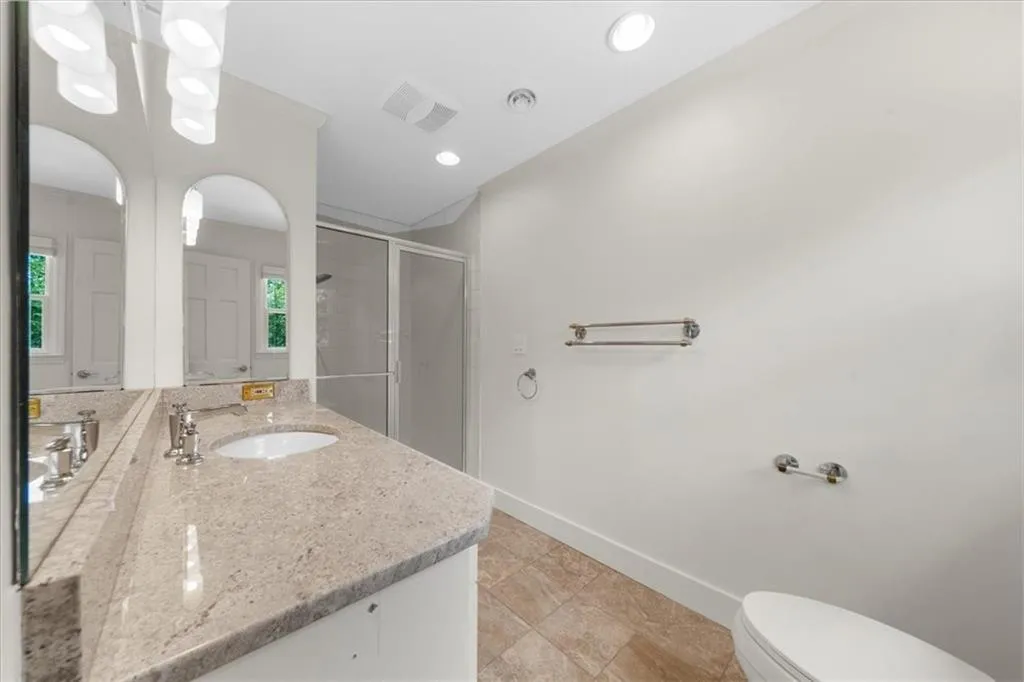 Full bathroom featuring vanity, a stall shower, and recessed lighting