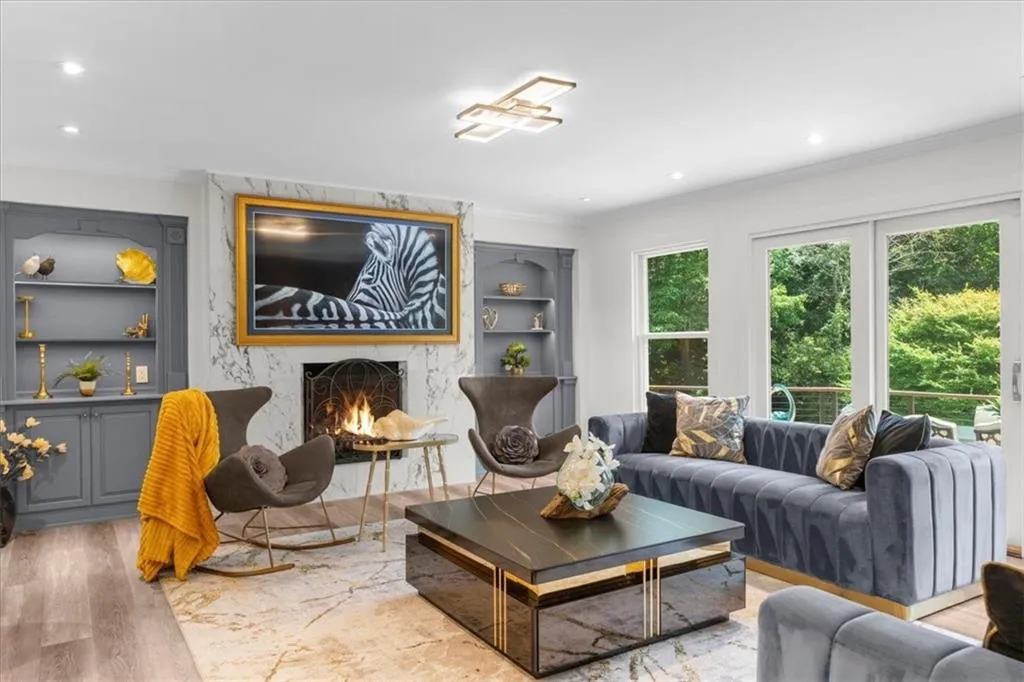 Living room with built in features, a fireplace, wood finished floors, ornamental molding, and recessed lighting