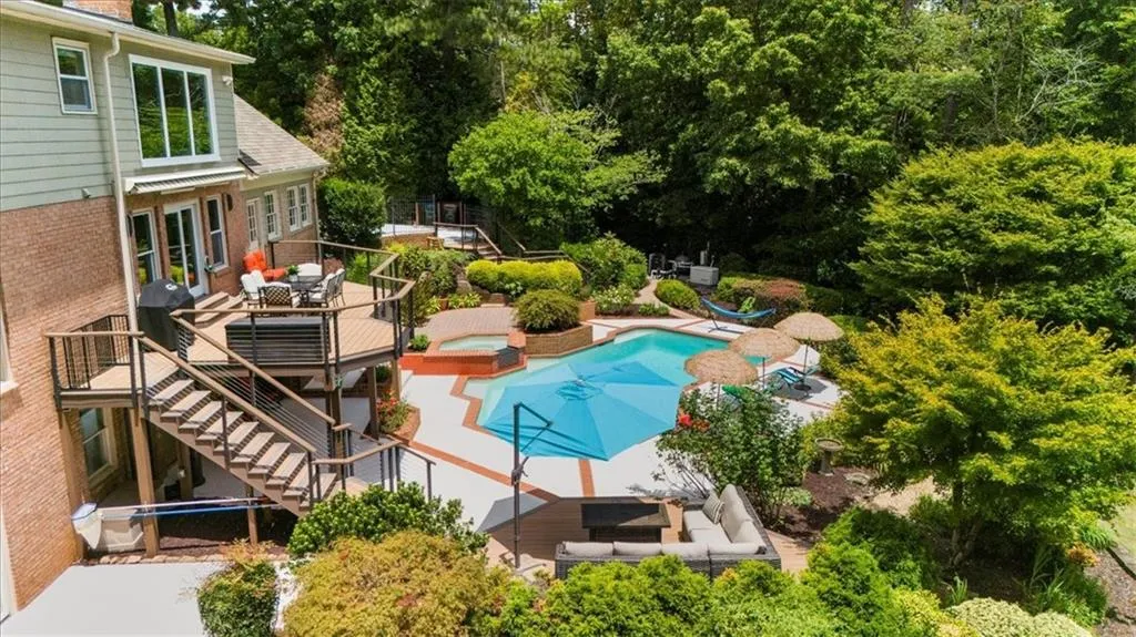 Outdoor pool featuring an in-ground hot tub, a deck, outdoor dining space, a patio, and stairs