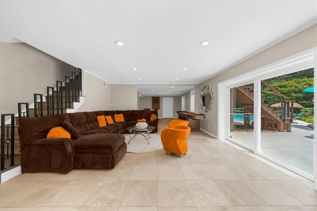 Living area with stairs, recessed lighting, crown molding, and light tile patterned floors