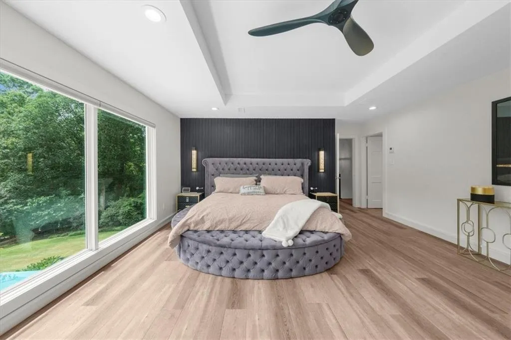 Bedroom with recessed lighting, wood finished floors, ceiling fan, and a raised ceiling