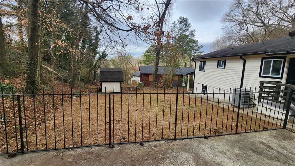 View of yard featuring an outbuilding, fence, and a storage unit