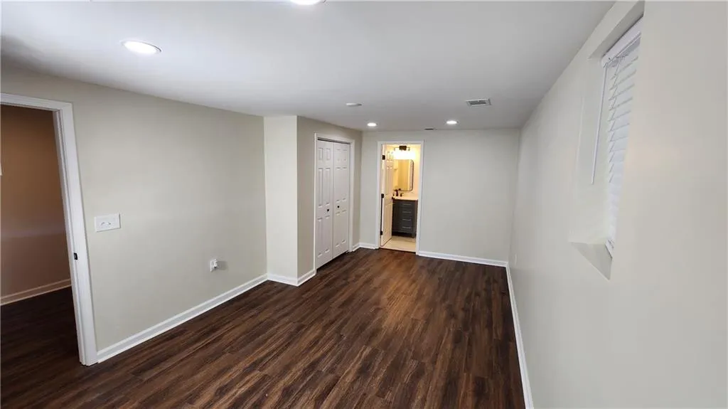 Room featuring recessed lighting, dark wood-style flooring, visible vents, and baseboards