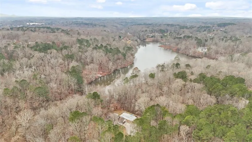 Aerial view of property's location with a heavily wooded area
