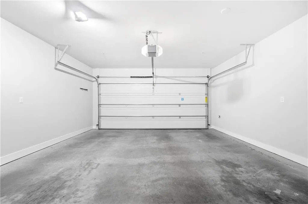 Garage with baseboards and a garage door opener