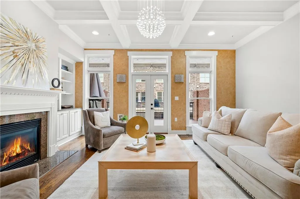 Living area featuring built in features, coffered ceiling, wood finished floors, a high end fireplace, and crown molding
