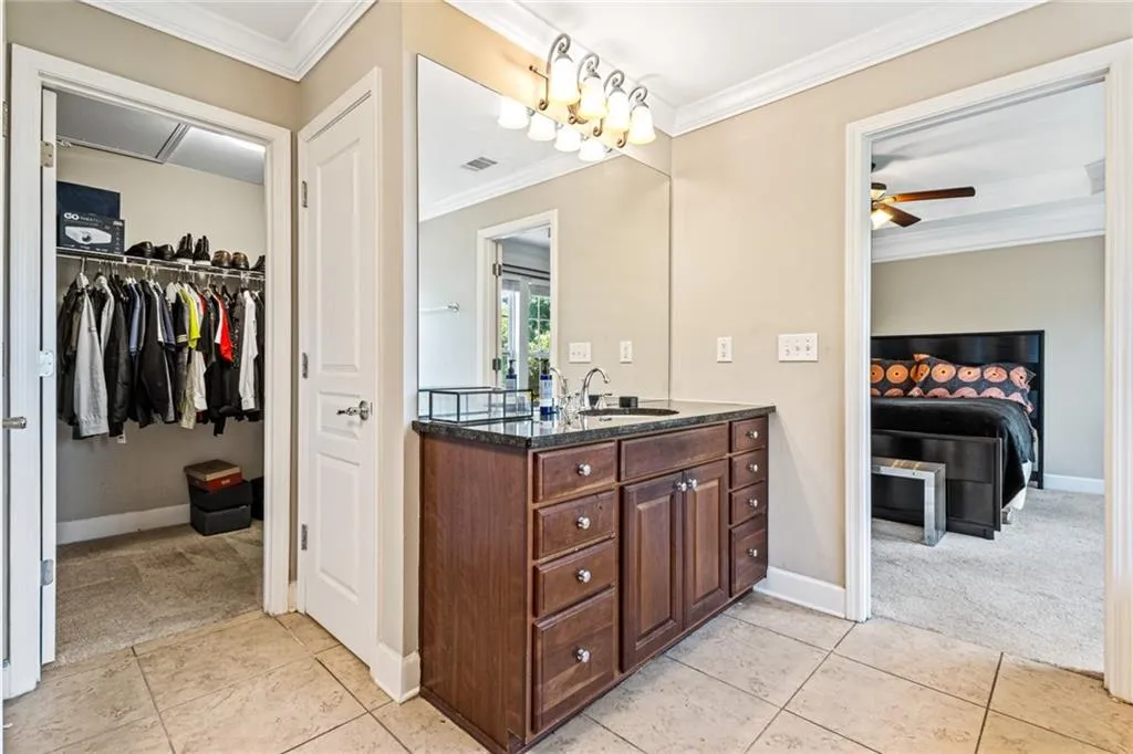 Bathroom with crown molding, vanity, ensuite bath, a ceiling fan, and tile patterned floors