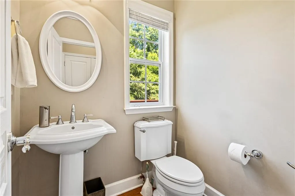 Half bath with baseboards and toilet