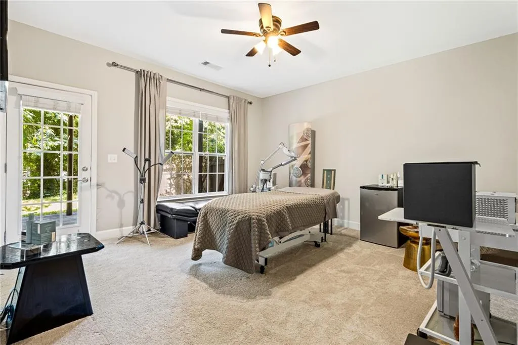 Bedroom with carpet flooring, freestanding refrigerator, access to exterior, a desk, and ceiling fan