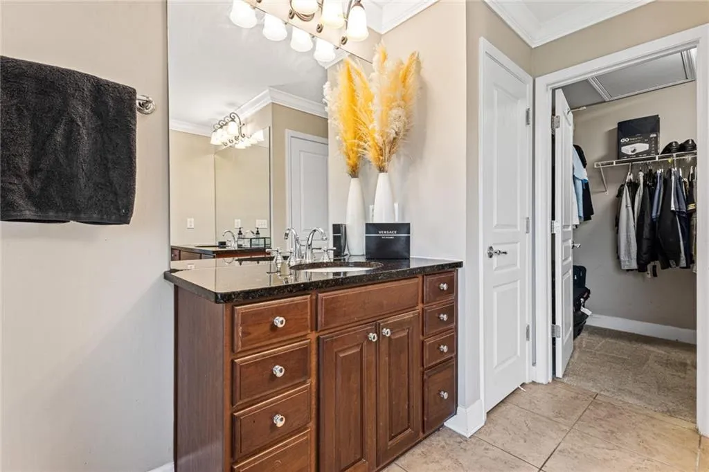 Full bathroom featuring ornamental molding, vanity, tile patterned flooring, and a spacious closet