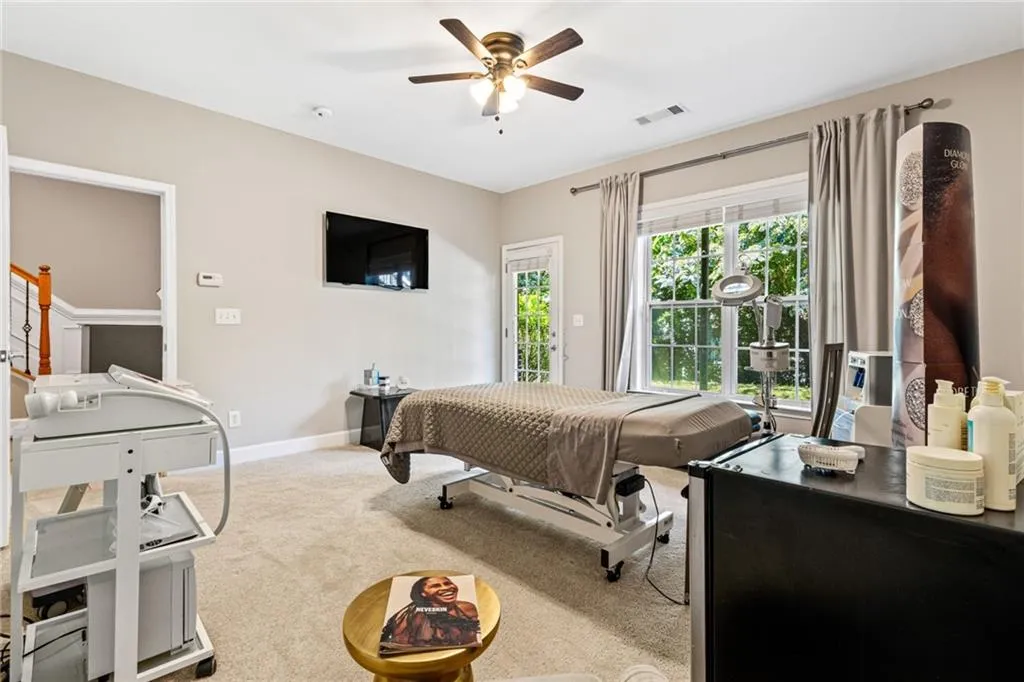 Carpeted bedroom with ceiling fan and access to exterior