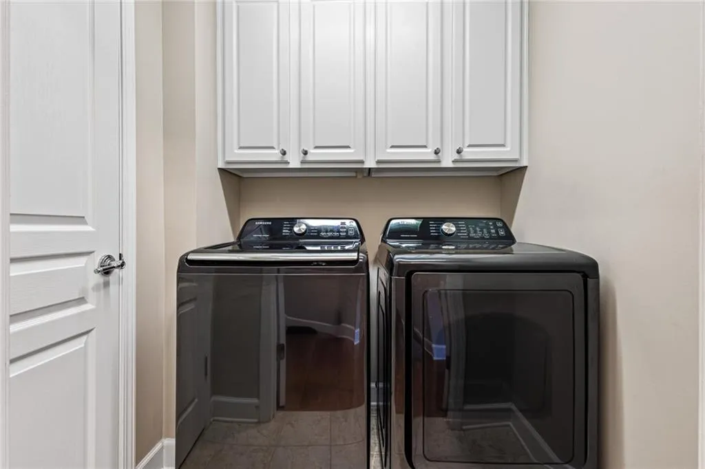 Laundry room with separate washer and dryer and cabinet space