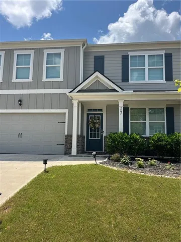 Two-story exterior with a covered entry, attached two-car garage, and established landscaping