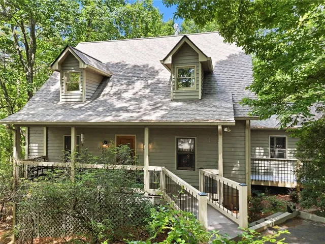 Two-story residence featuring dormer windows, a covered front porch, and horizontal siding