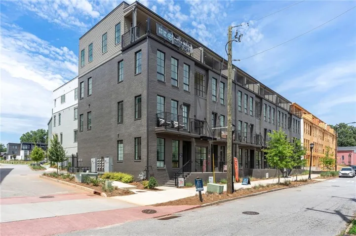 Modern multi-story building featuring dark brick and light-colored siding