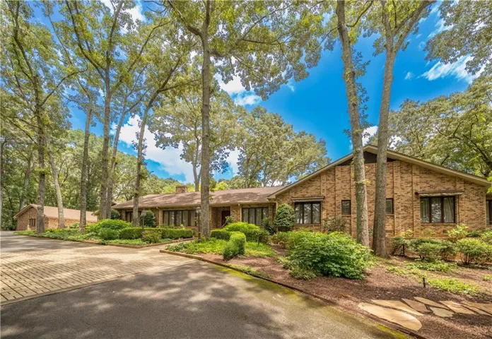 A hidden approach, framed by lush landscaping, sets the tone for this extraordinary property