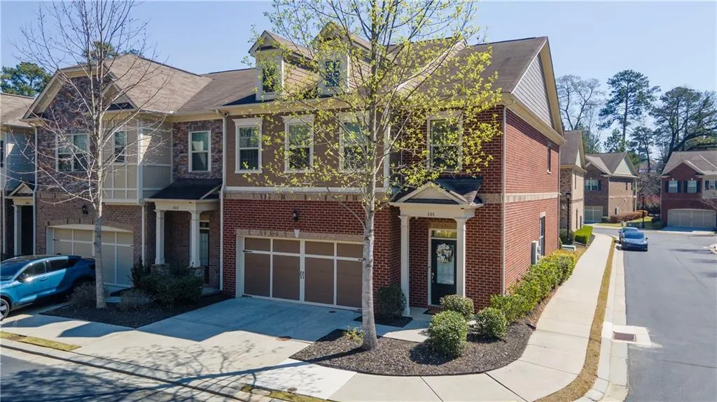 View of front of house featuring driveway, an attached garage, brick siding, and a shingled roof