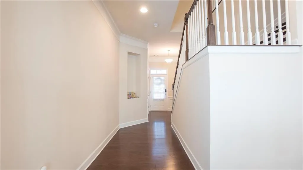 Hallway with crown molding, dark wood-type flooring, and recessed lighting