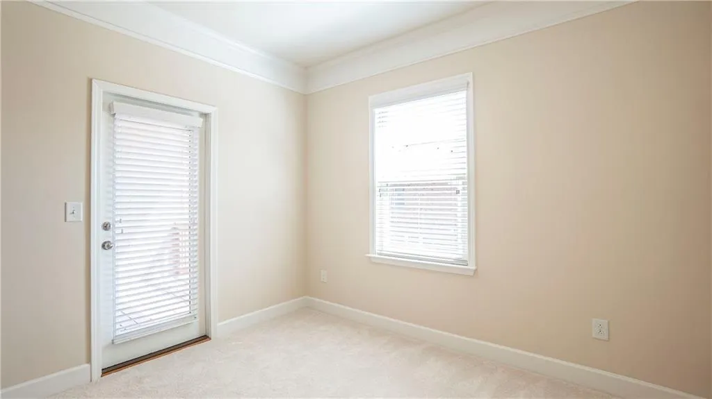 Unfurnished room featuring light carpet and crown molding