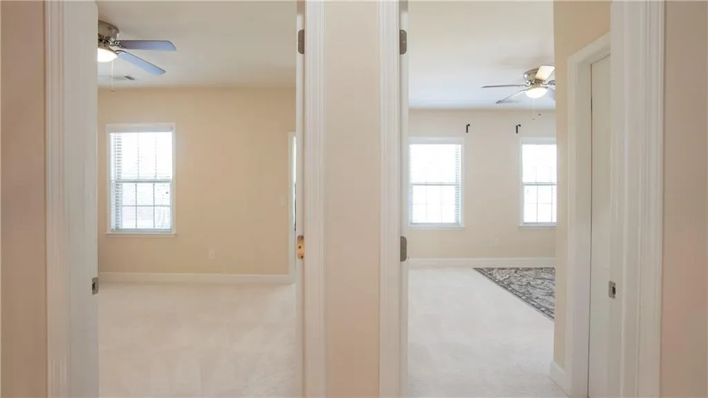 Corridor featuring light carpet and baseboards