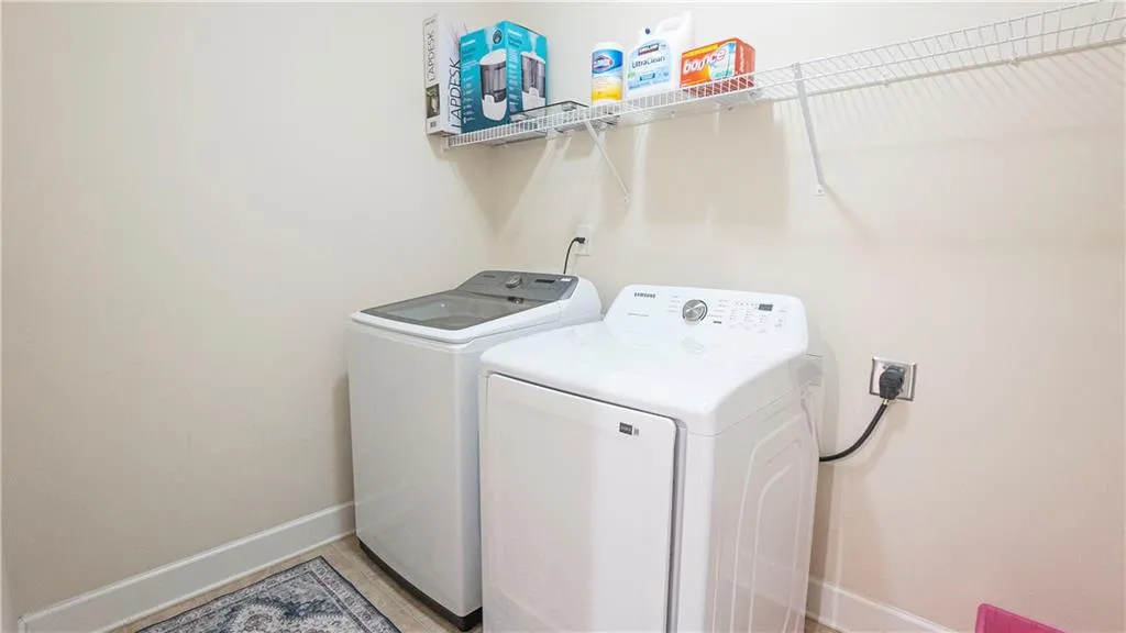 Laundry room with baseboards and washing machine and dryer