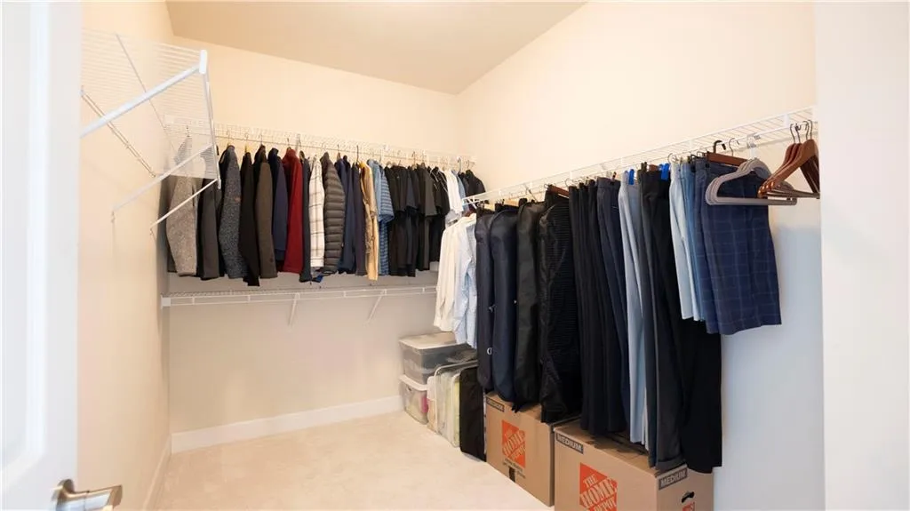 Walk in closet with light carpet