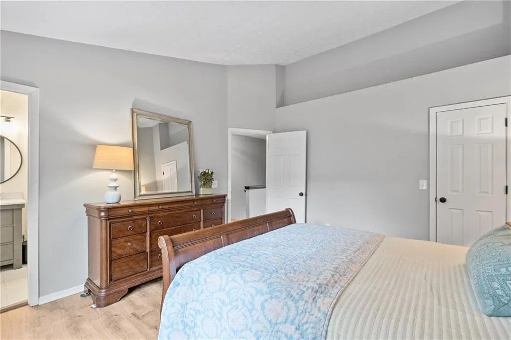Bedroom featuring wood finished floors and connected bathroom