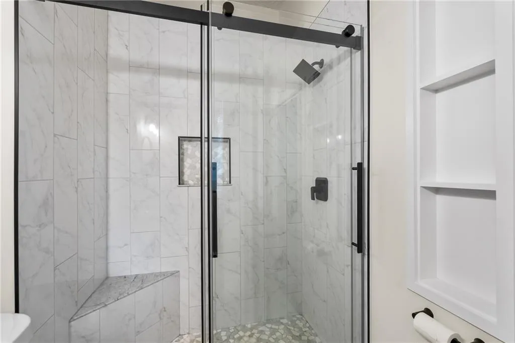 Full bath featuring a marble finish shower