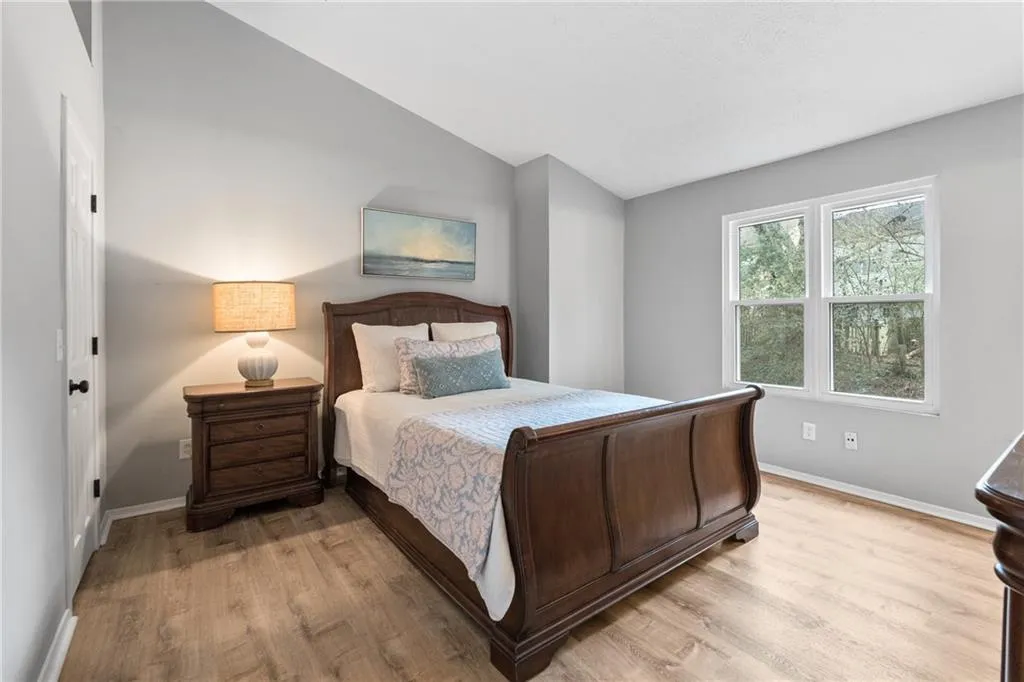 Bedroom with lofted ceiling and light wood-style flooring