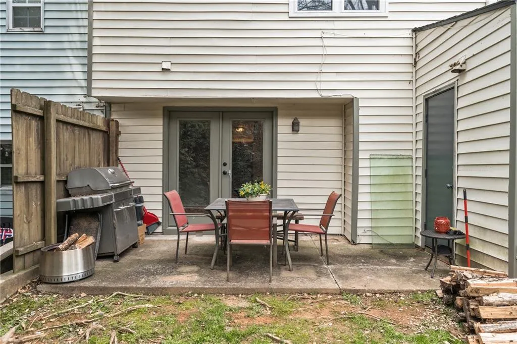 View of patio with area for grilling, outdoor dining space, and french doors