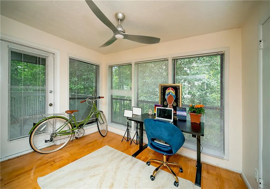 Home office with ceiling fan, plenty of natural light, baseboards, and wood finished floors