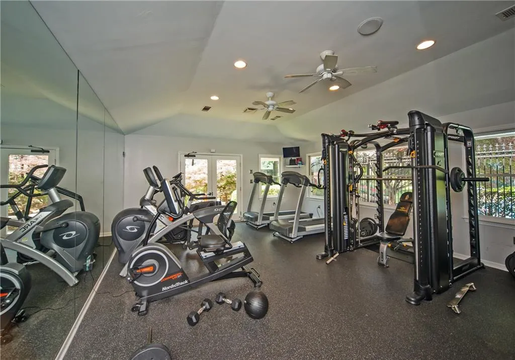 Workout area with plenty of natural light, vaulted ceiling, recessed lighting, and ceiling fan