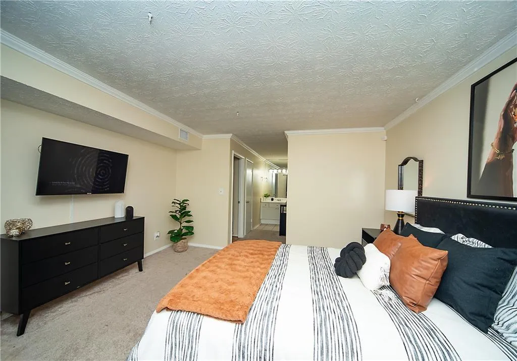 Bedroom featuring light colored carpet, crown molding, and baseboards