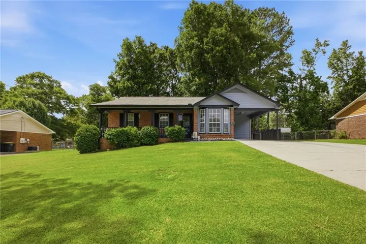 Brick exterior with a covered front porch featuring wrought iron railing