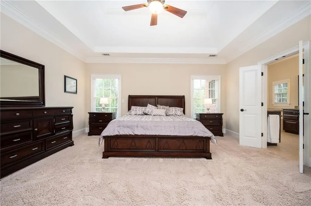 Primary Bedroom featuring a double trey ceiling and crown molding