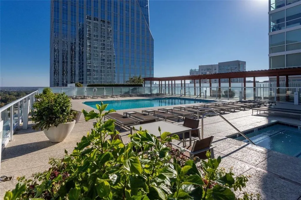 View of swimming pool with a community hot tub and a patio area View of swimming pool with a community hot tub and a patio area