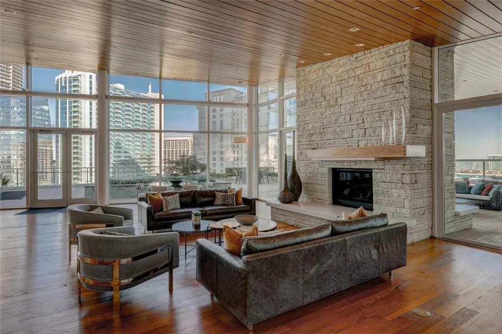 Living room with dark hardwood / wood-style flooring, wooden ceiling, a fireplace, and floor to ceiling windows Living room with dark hardwood / wood-style flooring, wooden ceiling, a fireplace, and floor to ceiling windows