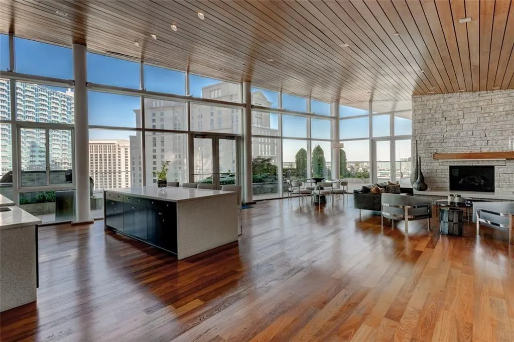 Kitchen featuring dark wood-type flooring, wooden ceiling, a stone fireplace, and a healthy amount of sunlight Kitchen featuring dark wood-type flooring, wooden ceiling, a stone fireplace, and a healthy amount of sunlight