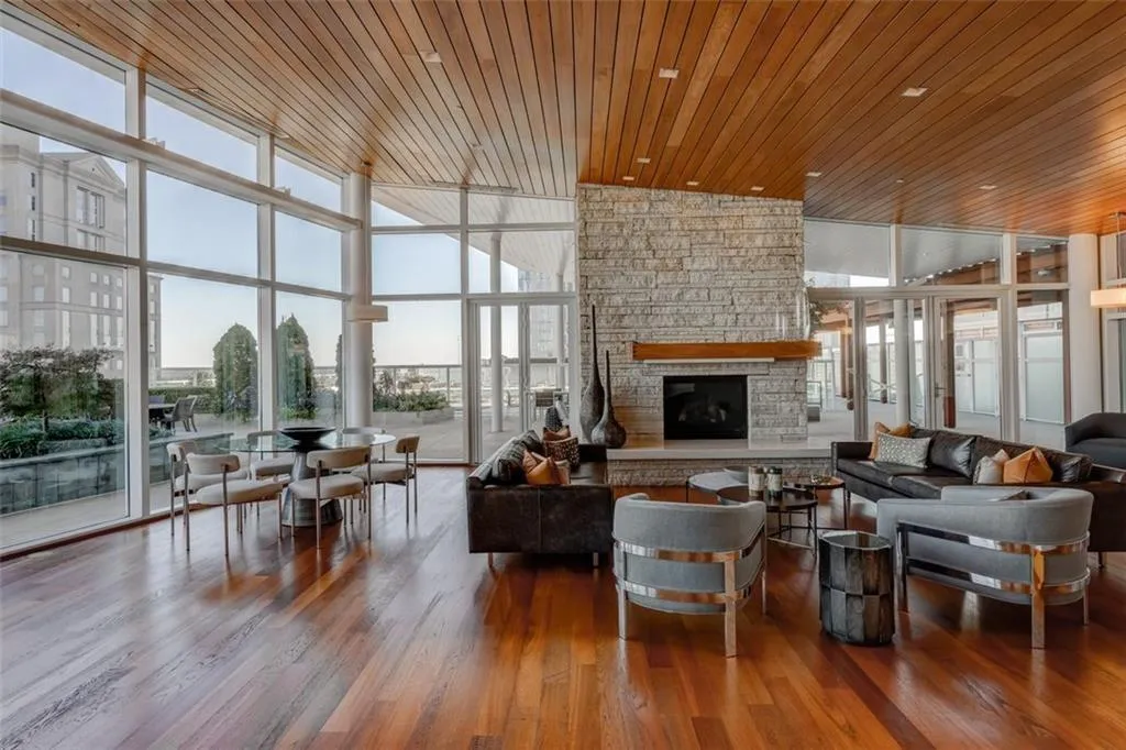 Living room with high vaulted ceiling, wood ceiling, dark wood-type flooring, and a stone fireplace Living room with high vaulted ceiling, wood ceiling, dark wood-type flooring, and a stone fireplace
