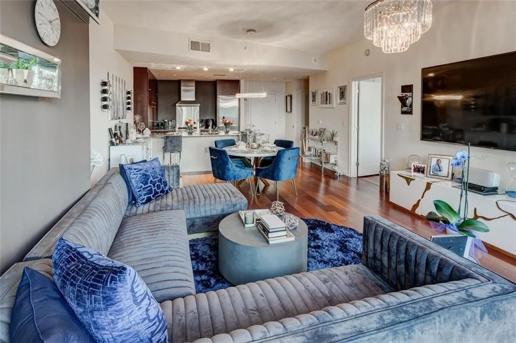 Living room featuring dark hardwood / wood-style flooring and a notable chandelier Living room featuring dark hardwood / wood-style flooring and a notable chandelier