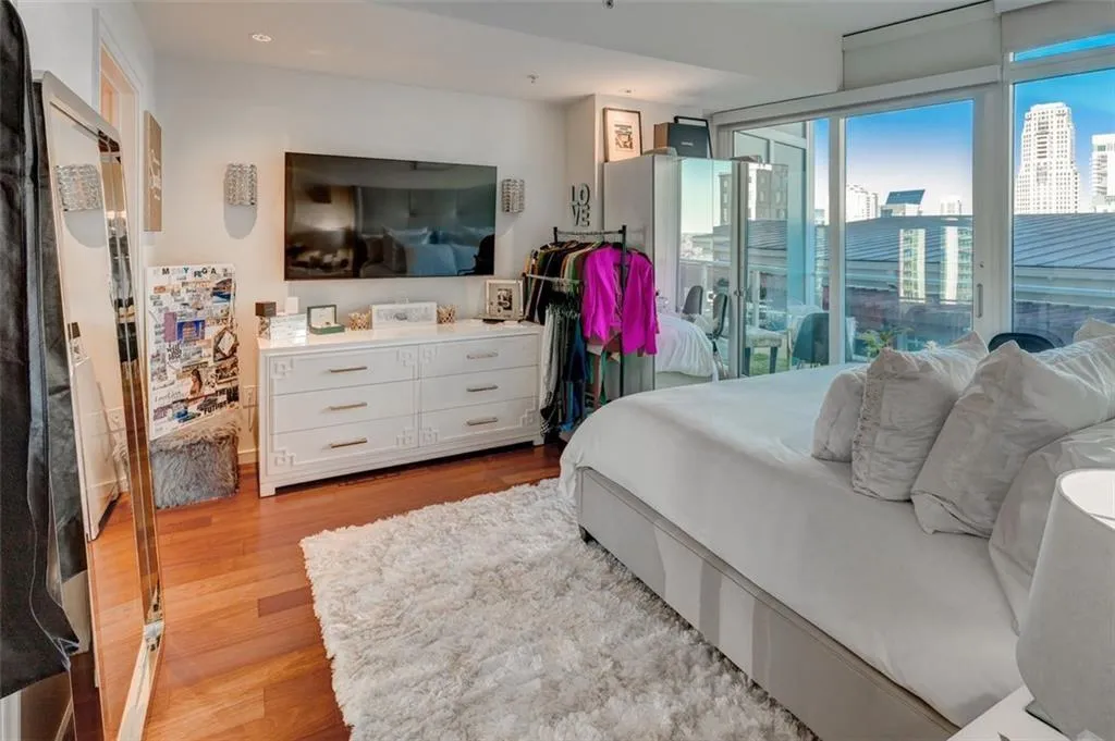 Bedroom with expansive windows, light hardwood / wood-style floors, and access to exterior Bedroom with expansive windows, light hardwood / wood-style floors, and access to exterior