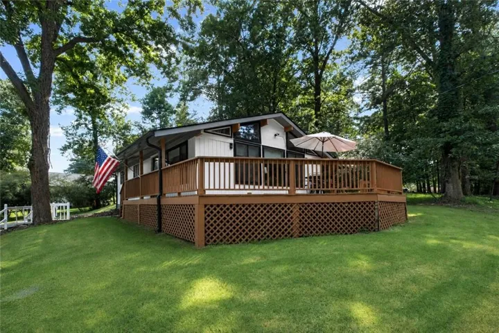 Expansive outdoor deck with wood railing and lattice skirting