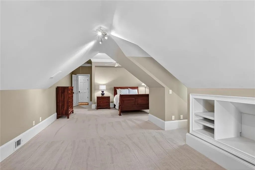 Unfurnished bedroom with light colored carpet and vaulted ceiling