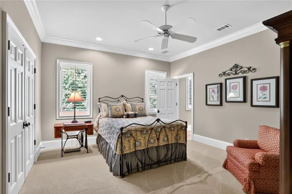 Bedroom with a closet, light carpet, ornamental molding, recessed lighting, and ceiling fan