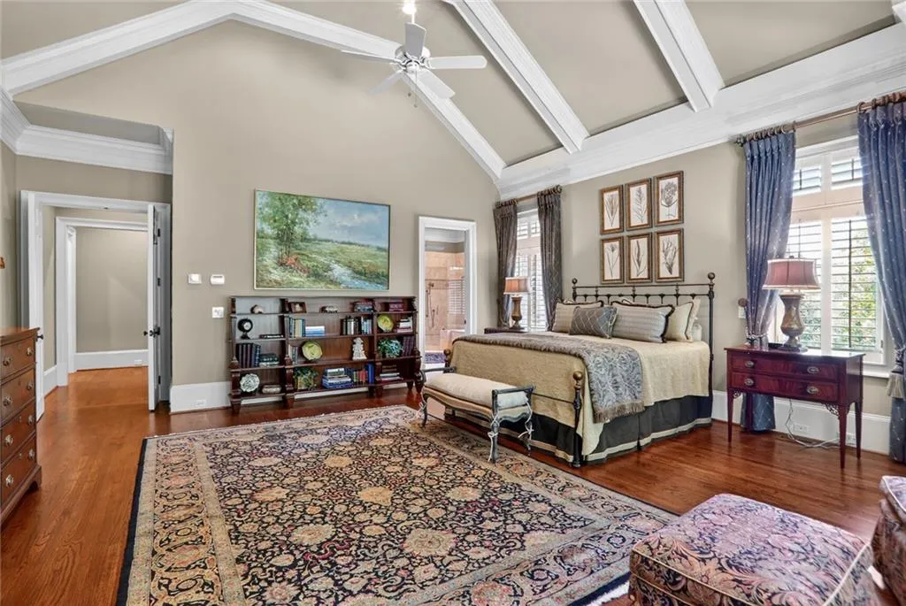 Bedroom featuring dark wood finished floors, high vaulted ceiling, a ceiling fan, and crown molding