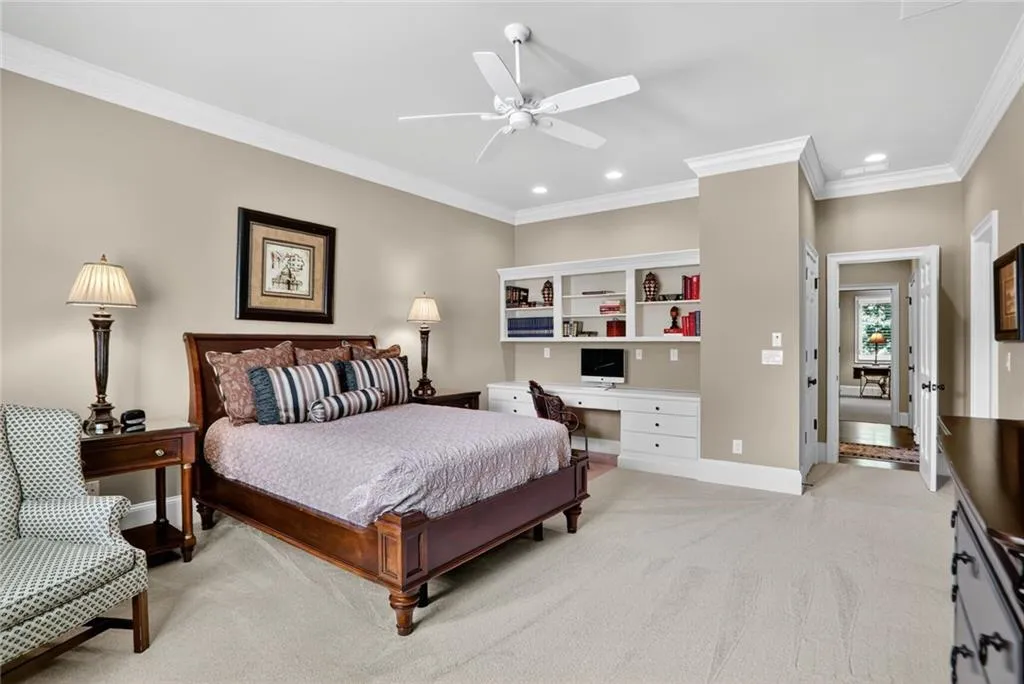 Bedroom featuring ornamental molding, light carpet, a ceiling fan, recessed lighting, and built in desk